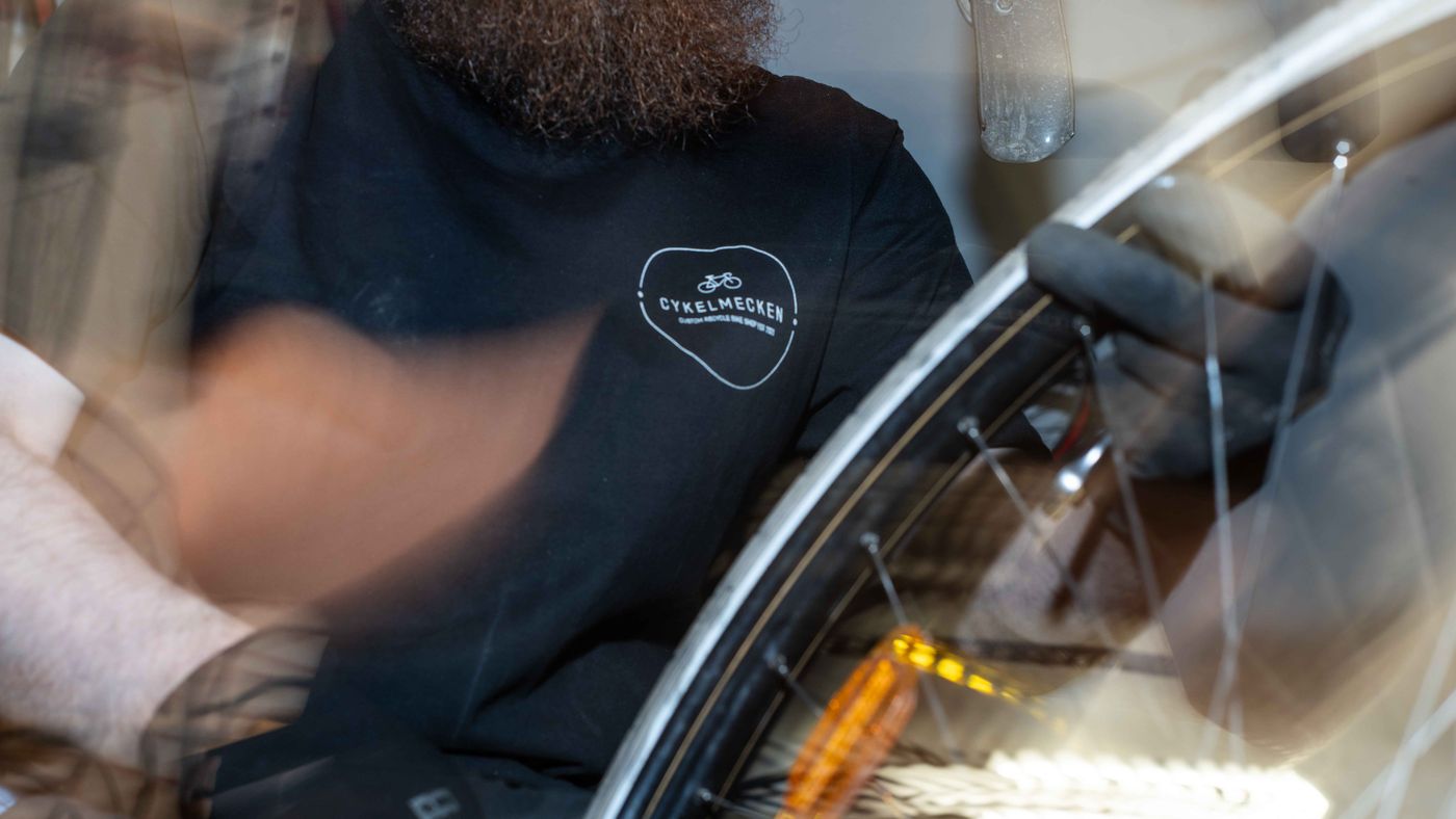 Mekaniker arbetar med ett cykelhjul i verkstaden